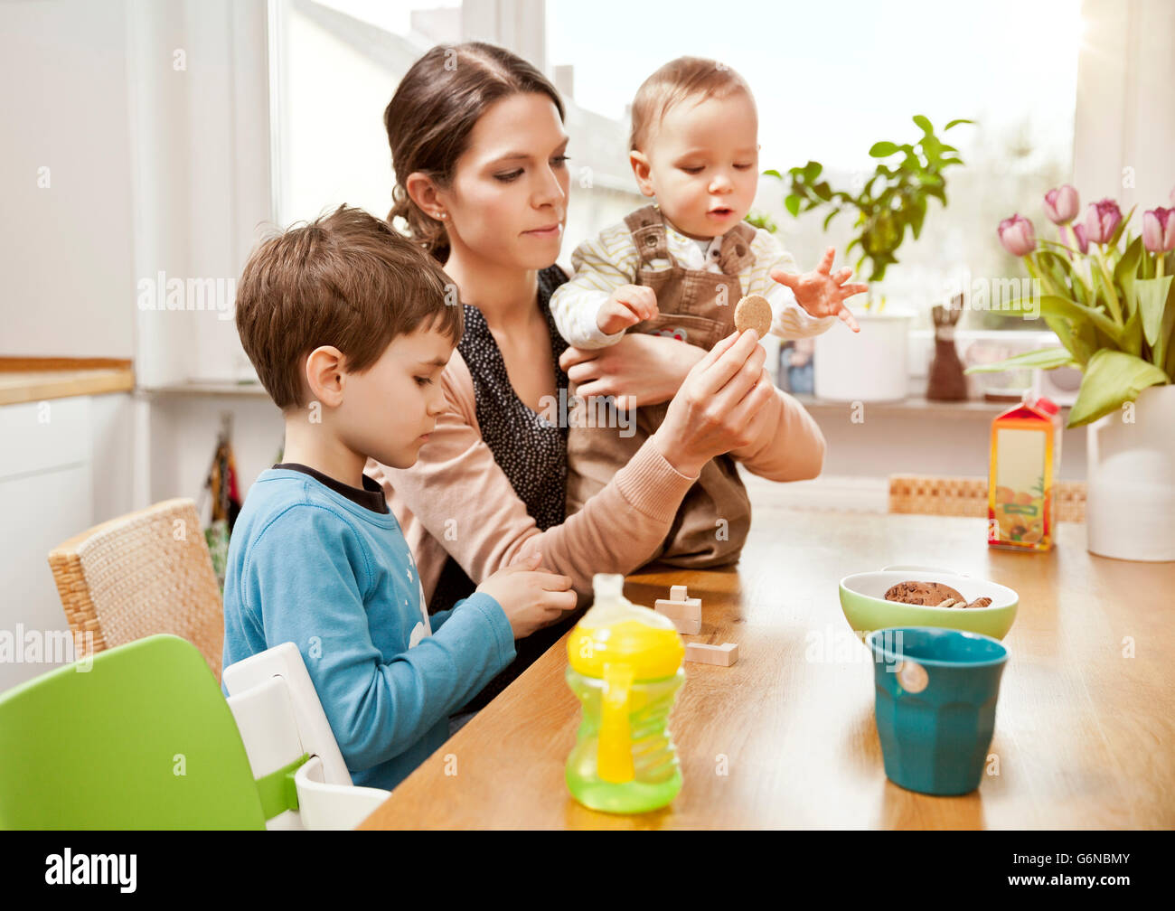 Mother with her little sons in the kitchen Stock Photo