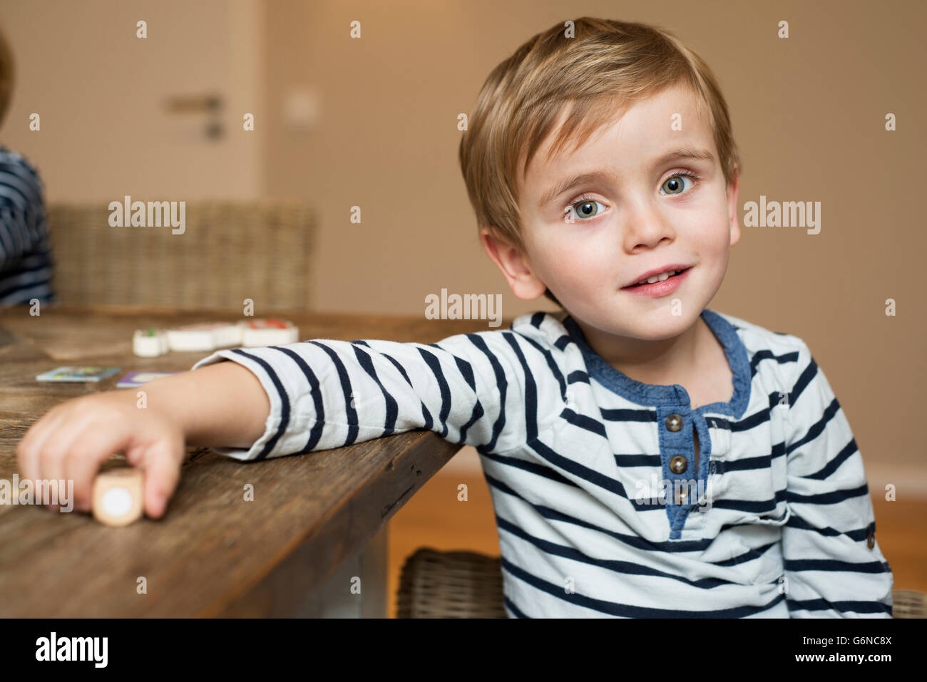 Liitle boy sitting at table, portrait Stock Photo Alamy