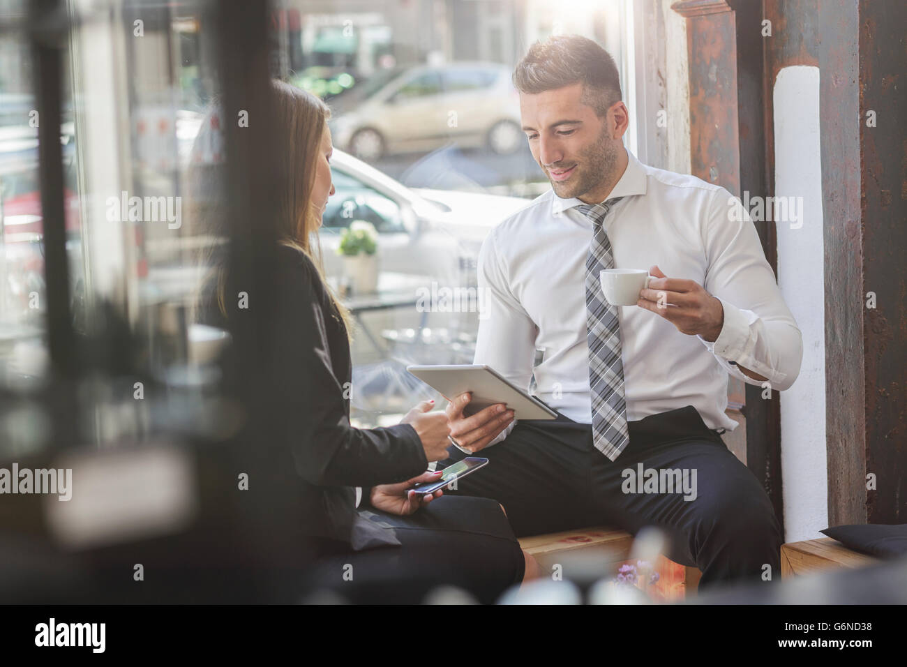 Businessman and businesswoman with digital tablet and smartphone in a cafe Stock Photo
