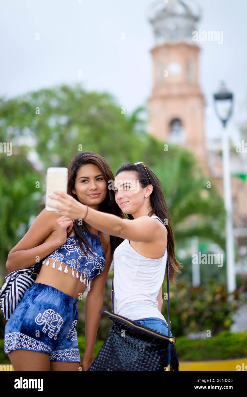 Mexico, Puerto Vallarta, two young women taking a smartphone selfie in ...