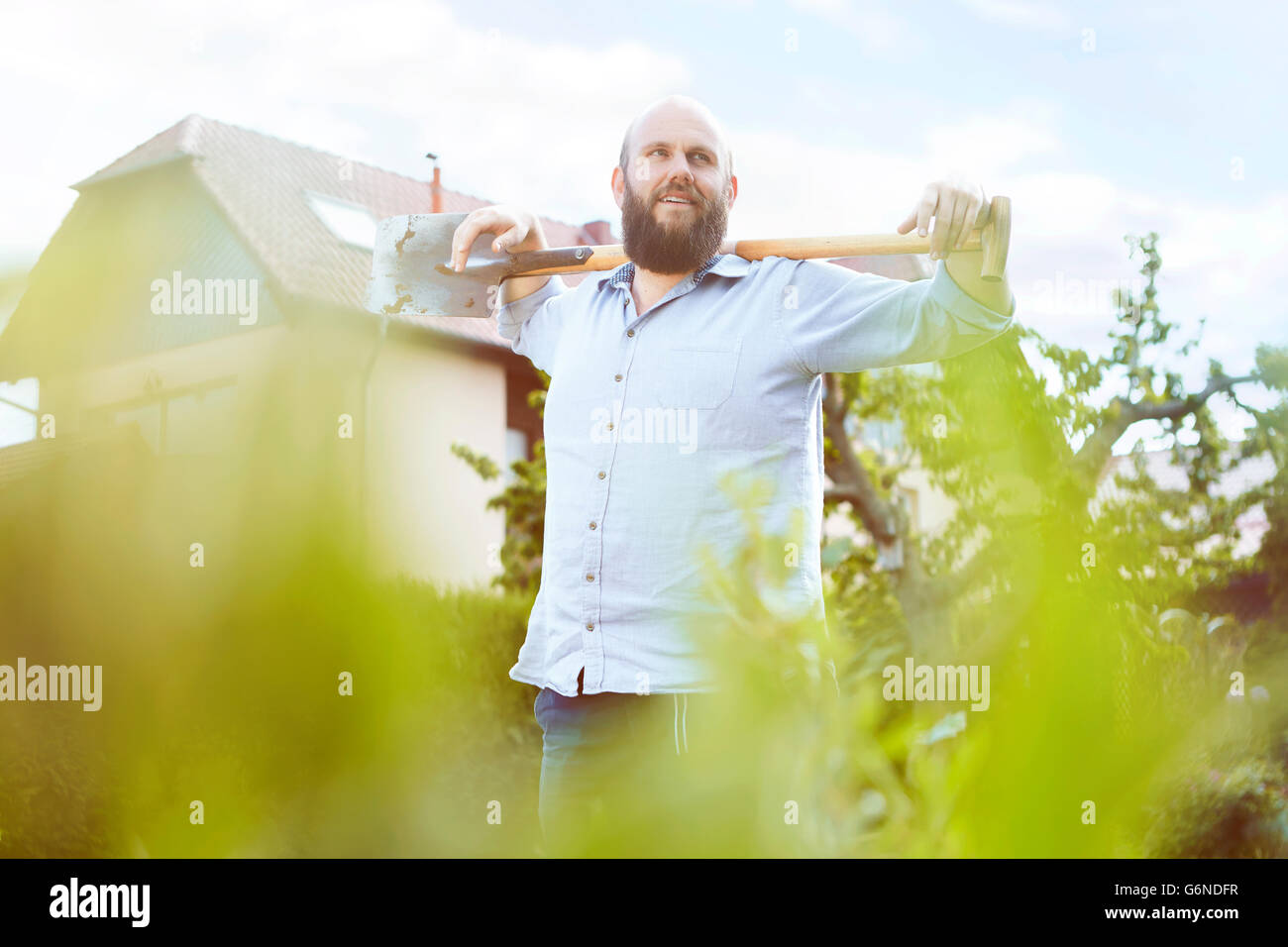 Young man posing with shovel in garden Stock Photo - Alamy