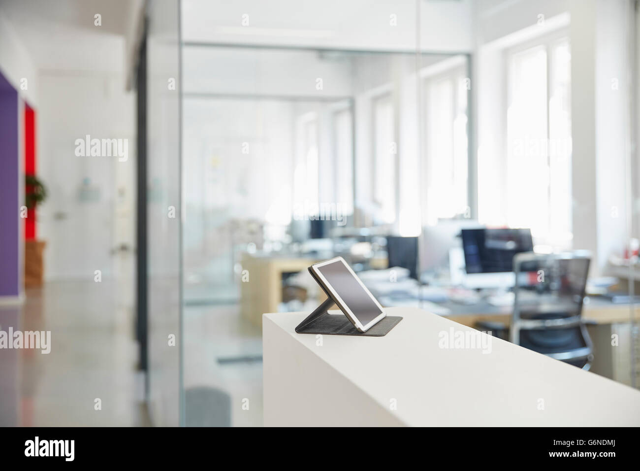 Interior of bright modern office with digital tablet on ledger Stock Photo