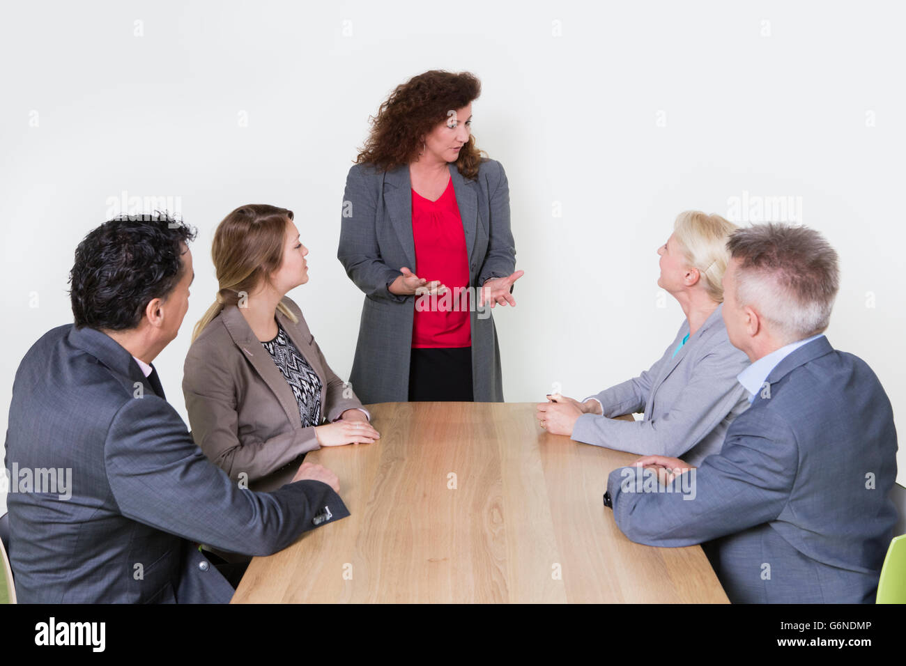 Business presentation in conference room, business person standing and  coworkers sitting at the desk and listening Stock Photo