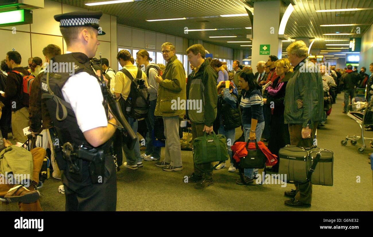 BA 223 takes off from Heathrow. Passengers board BA 223 watched by armed police at Heathrow's Terminal 4. Stock Photo