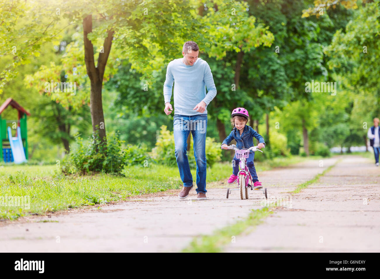 Father accompanying daughter on bike Stock Photo