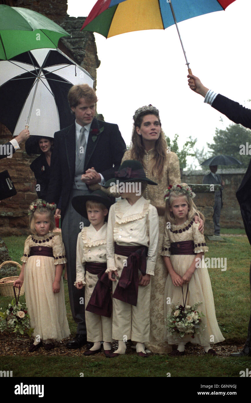 Viscount Althorp joins hands with his bride Victoria Lockwood after their wedding ceremony at St. Mary's Church in Great Brington, Northamptonshire. Page boys Prince Harry and Alexander Fellowes, alongside bridesmaids Emily McCorguodale and Eleanor Fellowes, are also with them. Stock Photo