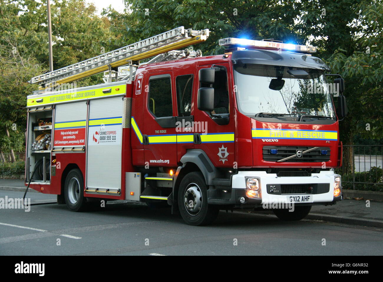 A VOLVO FIRE TRUCK OF EAST SUSSEX FIRE & RESCUE ATTENDING A FIRE WITH BLUE LIGHTS FLASHING. Stock Photo
