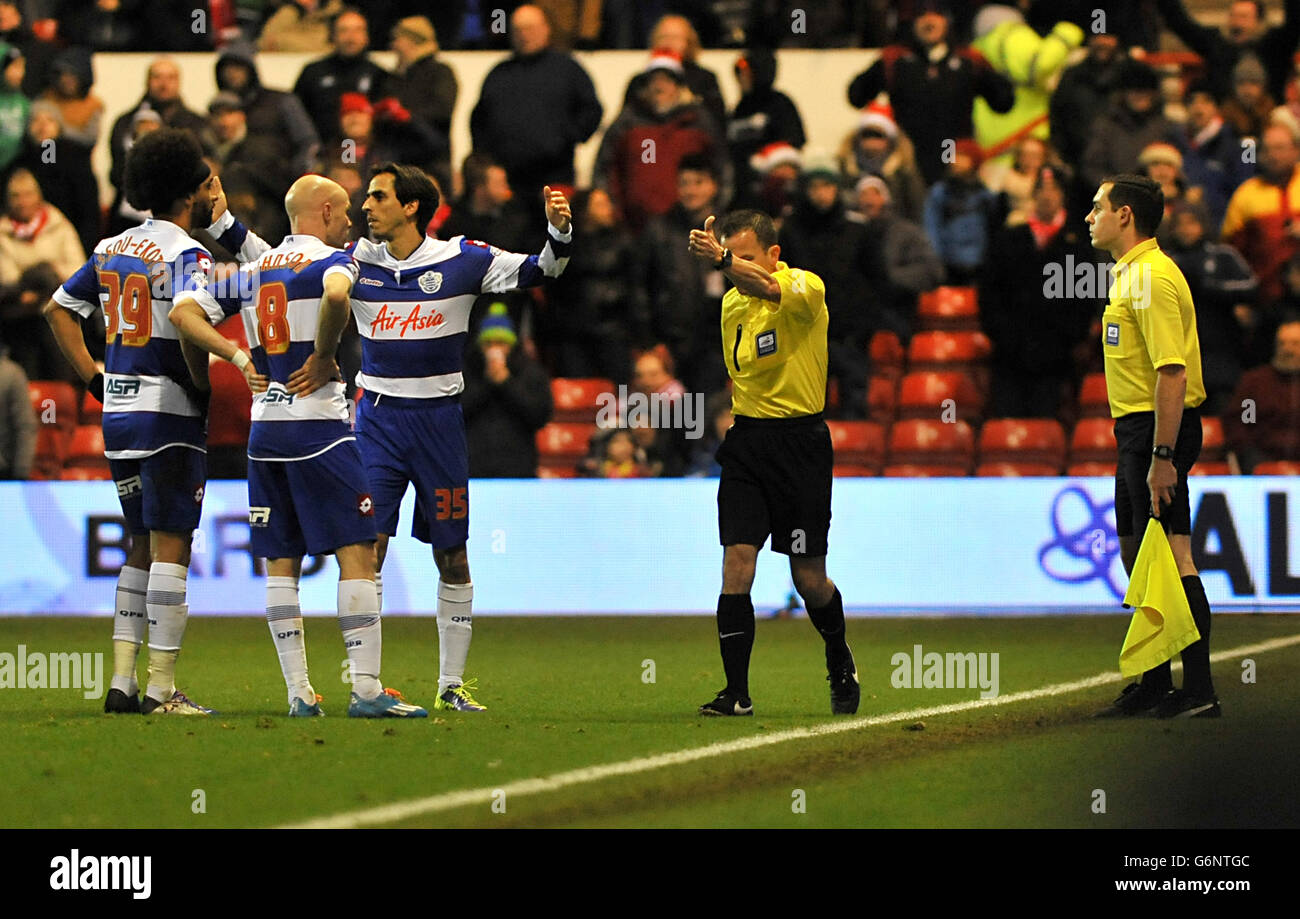 Queens Park Rangers react after Match referee Kevin Stroud gives Nottingham Forest's second goal following a conversation with his assistant Edward Smart (right) Stock Photo