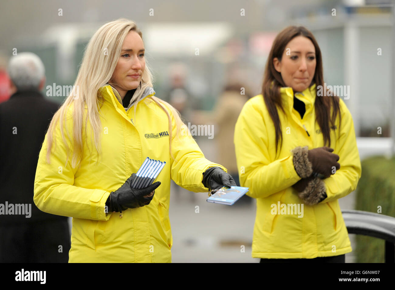 Horse Racing - 2013 William Hill Winter Festival - Day One - Kempton Park Racecourse. William Hill staff hand out the 2014 diary Stock Photo
