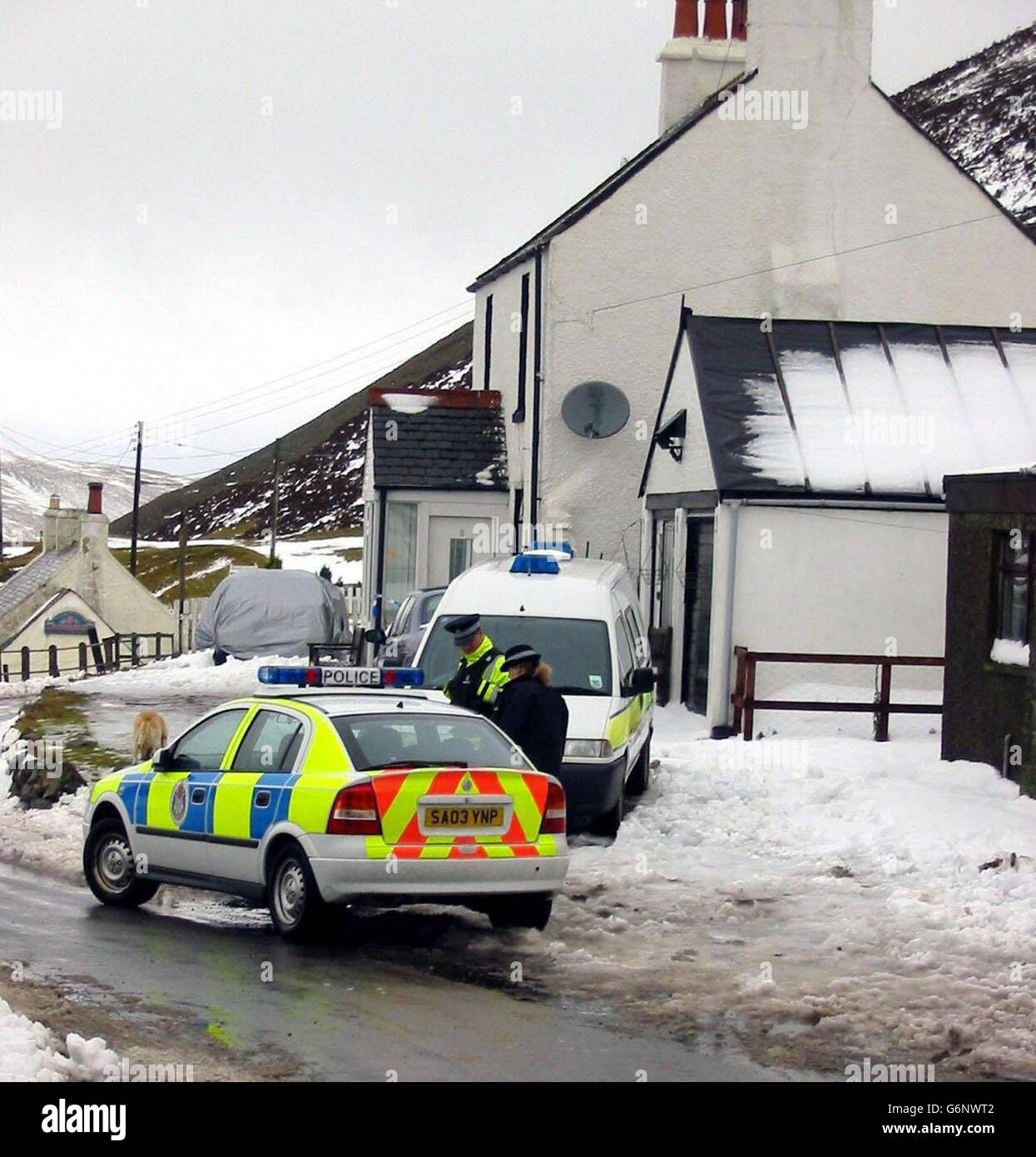 Two police officers stand outside 8 Church Street, Wanlockhead, near Sanquhar, Dumfries and Galloway, where a 60-year-old woman and a 13-year-old girl died in a house fire during the early hours of New Year's Day. Another person was taken to hospital. The cause of the fire was still being investigated by police and fire officers. Stock Photo