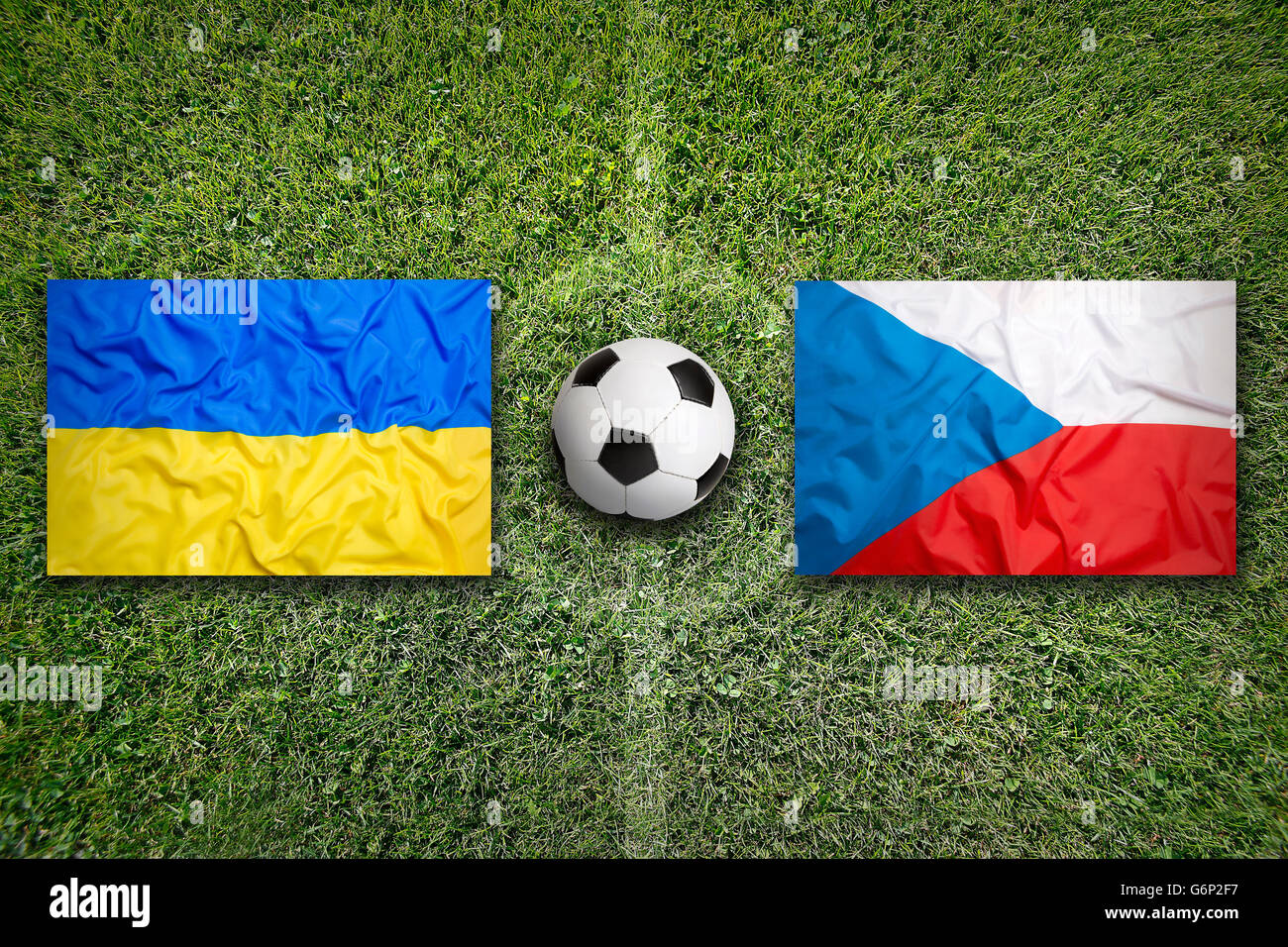 Ukraine vs. Czech Republic flags on green soccer field Stock Photo