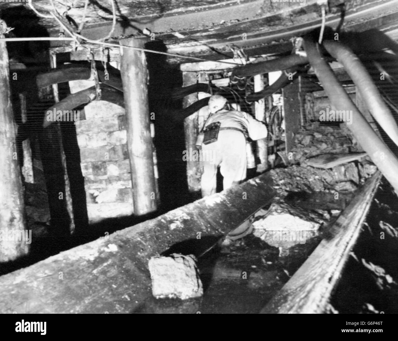 Inspection of Ellington Colliery's K12 main gate near the pit's most productive long wall face, with debris on the belt which normally carries coal out. Pressure has lowered the roof by nearly three-feet, trapping conveyor equipment and hydraulic pumps, claims the National Coal Board amid concerns of deteriorating conditions during the eight-month miners' strike. Stock Photo