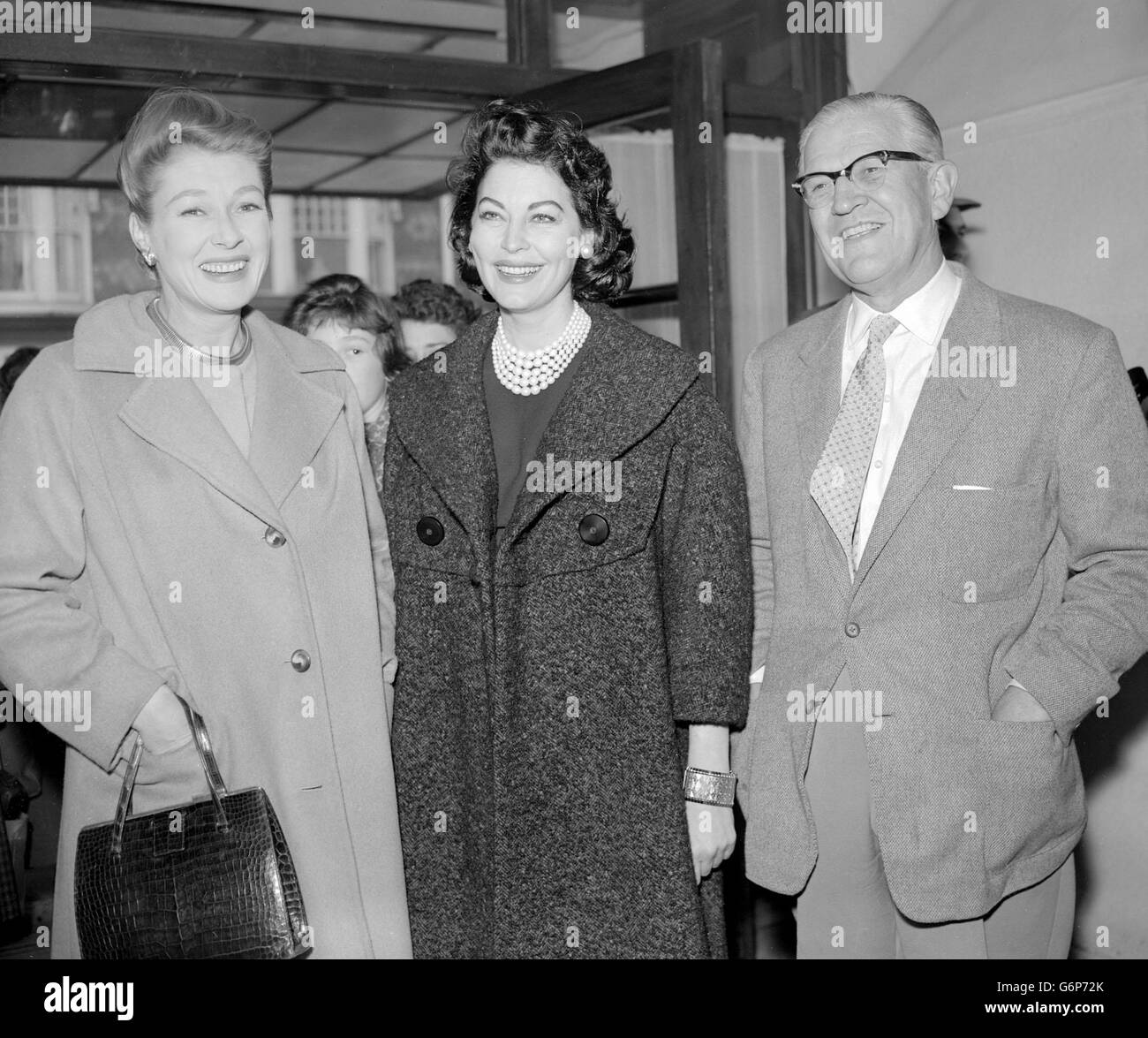 Ava Opens a Sale of Work. American film actress Ava Gardner is pictured with her friendes Sir Archibald Mcindoe, the plastic surgeon, and Lady McIndoe, when she opened a sale of work by nurses of the Queen Victoria Hospital, East Grinstead, Sussex, at the Whitehall Restaurant in East Grinstead today. Miss Gardner, who came from her home in Spain to open the sale, is spending the weekend with the McIndoes at their home near East Grinstead. Stock Photo