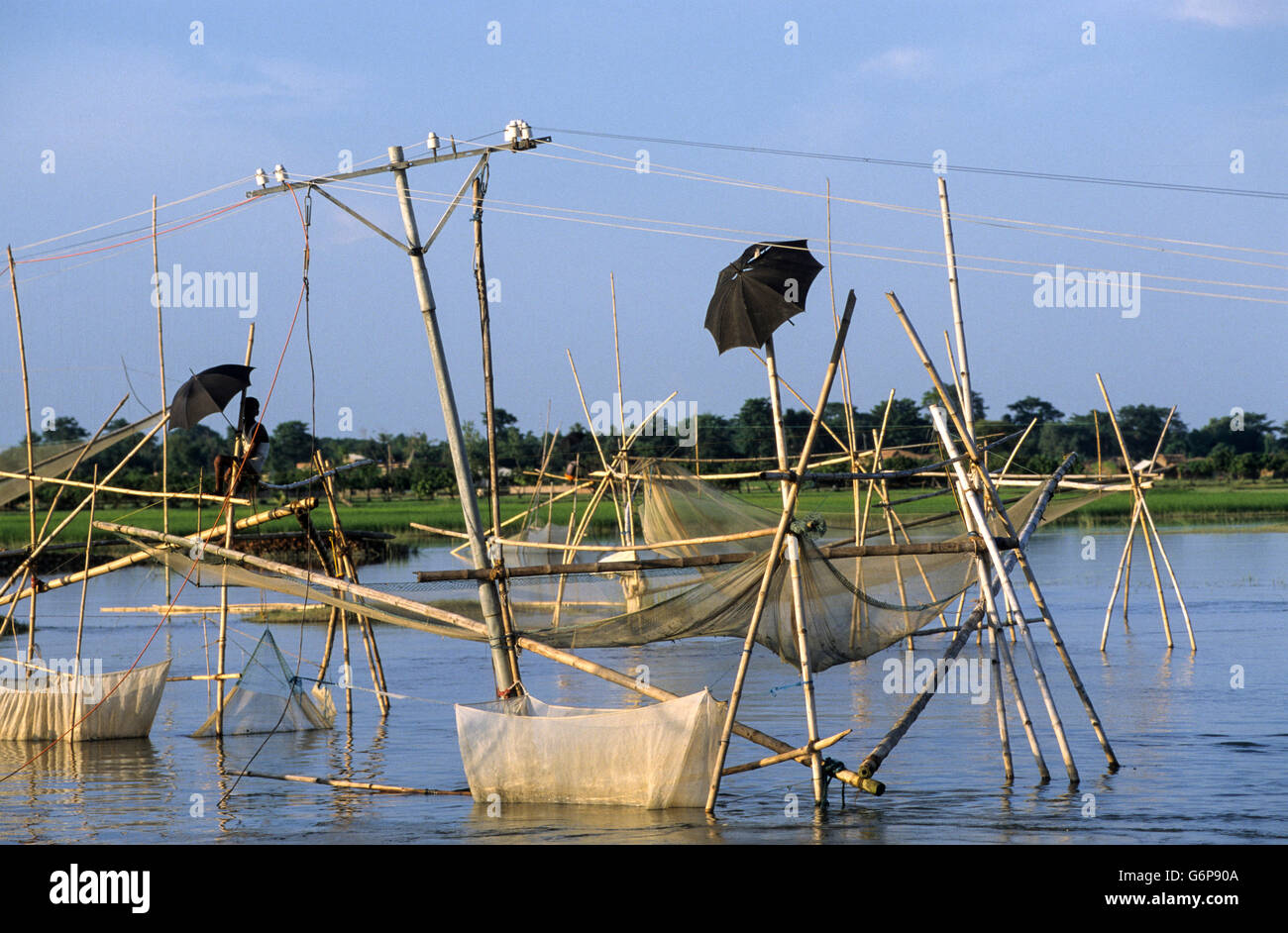 INDIA Bihar, submergence at Bagmati river a branch of Ganges / Ganga River due to heavy monsoon rains and melting Himalaya glaciers, people fishing on temporary bamboo construction, fishing net Stock Photo
