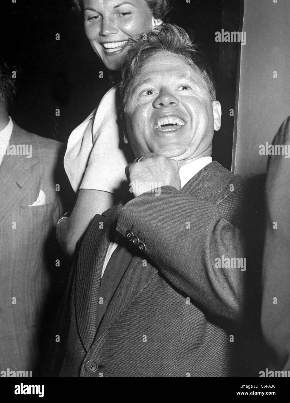 Hollywood's ever young Mickey Rooney may be small, but his smile certainly covers a lot of ground. Mickey, still with that rumpled-hair boyish look, despite the fact he's grown up now, was beaming good-fellowship on all the world when he took in a cocktail party in Hollywood. Stock Photo