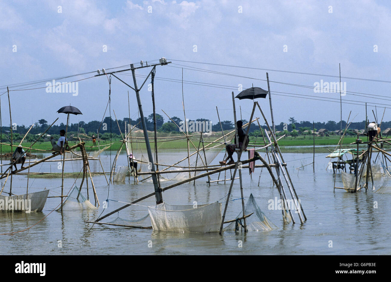 INDIA Bihar, submergence at Bagmati river a branch of Ganges / Ganga River due to heavy monsoon rains and melting Himalaya glaciers, people fishing on temporary bamboo construction, fishing net Stock Photo