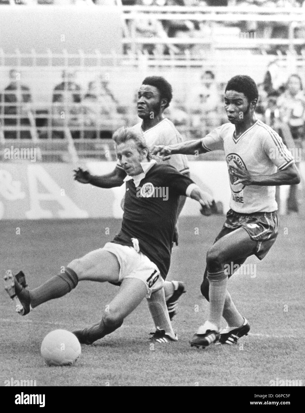 Scotland's Denis Law (dark shirt) breaks through Zaire's Boba Lobilo and Buhanga during the Group Two World Cup match at the Westfalenstadion in Dortmund. The match ended as a 2-1 victory for Scotland, with goals from Peter Lorimer and Joe Jordan. Stock Photo