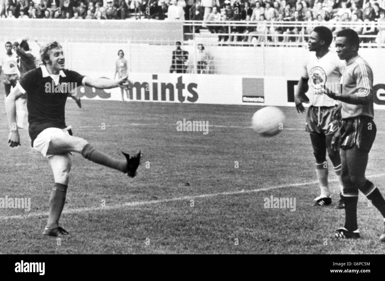 Denis Law jubilantly kicks the ball back into the net - a joke not shared by the dejected Zaire players - after teammate Peter Lorimer had scored Scotland's first goal in the Group Two World Cup match against Zaire at the Westfalenstadion in Dortmund. Stock Photo