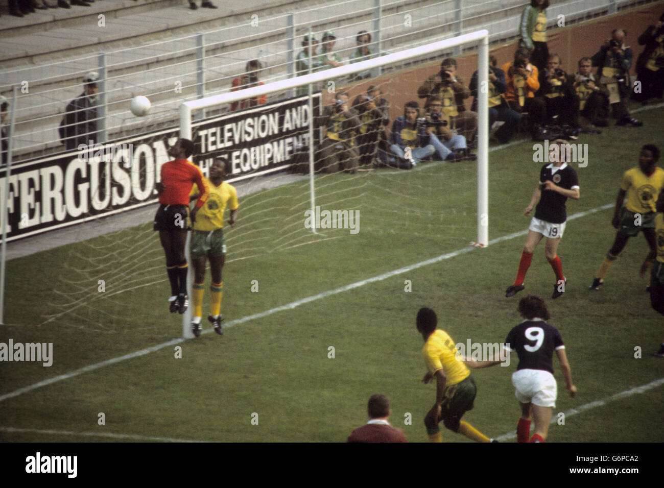 Soccer - FIFA World Cup West Germany 1974 - Group 2 - Zaire v Scotland - Westfalenstadion, Dortmund. Zaire goalkeeper Kazadi Muamba (l) watches as the ball goes over the crossbar. Pictured for Scotland (r) is Denis Law. Stock Photo