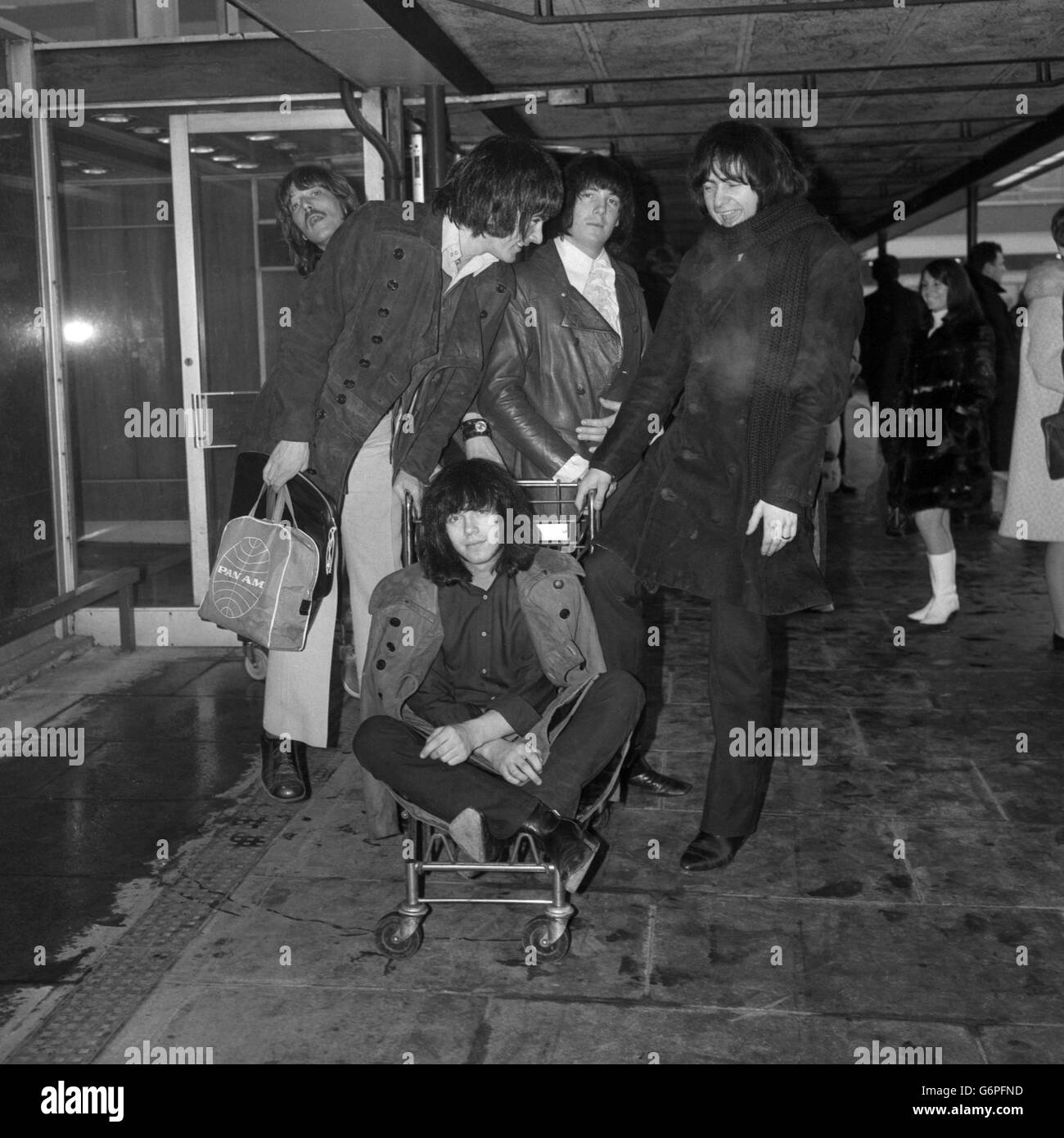 From l-r) Rod Evans, Jon Lord, Nicky Simper and Ritchie Blackmore, members  of English rock group Deep Purple, combine to give a luggage trolley ride  to Ian Paice at London Heathrow Airport.