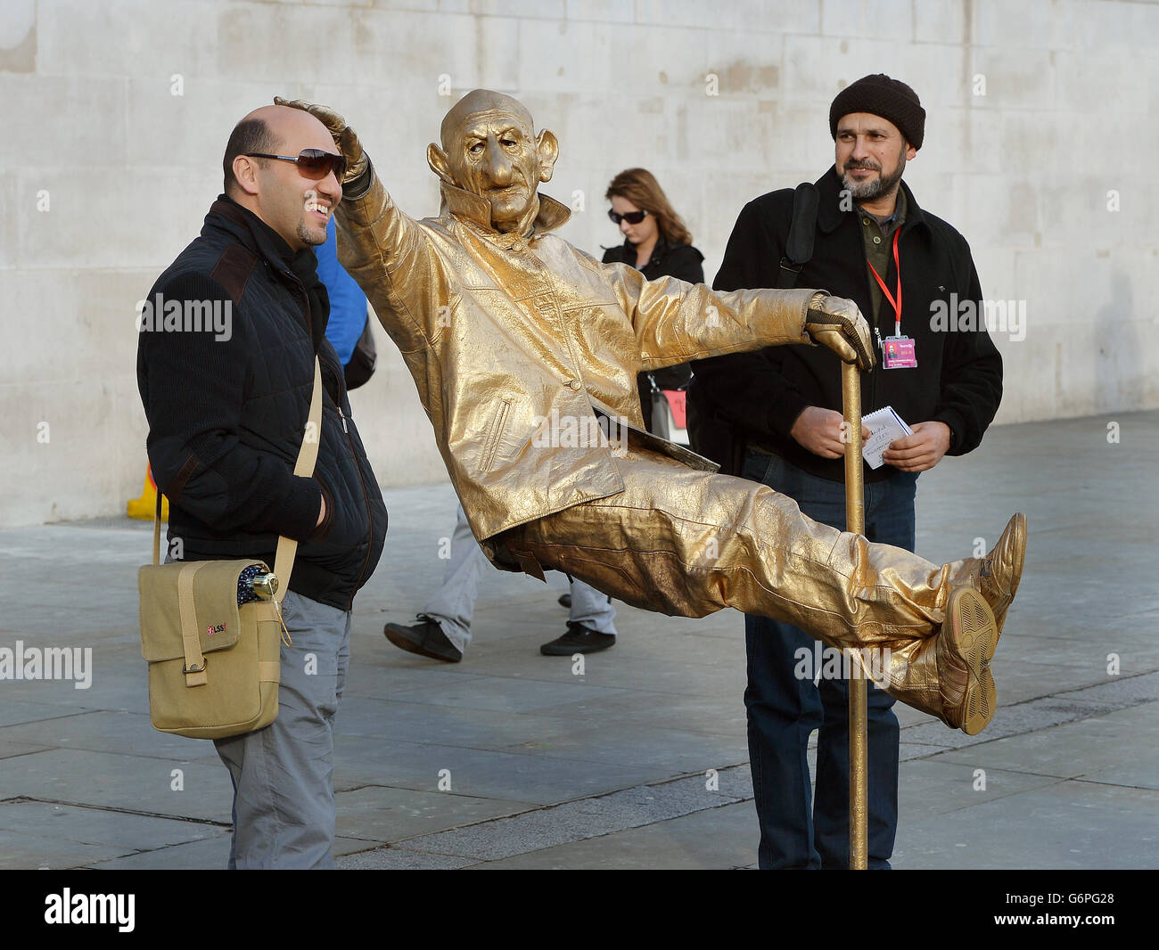 A human street Statue entertains tourists outside the National Gallery in Trafalgar Square, which was founded in 1824 and has a collection of 2,300 paintings dating from the mid-13th century 1900, and is a must visit attraction for foreign tourists visiting London. Stock Photo