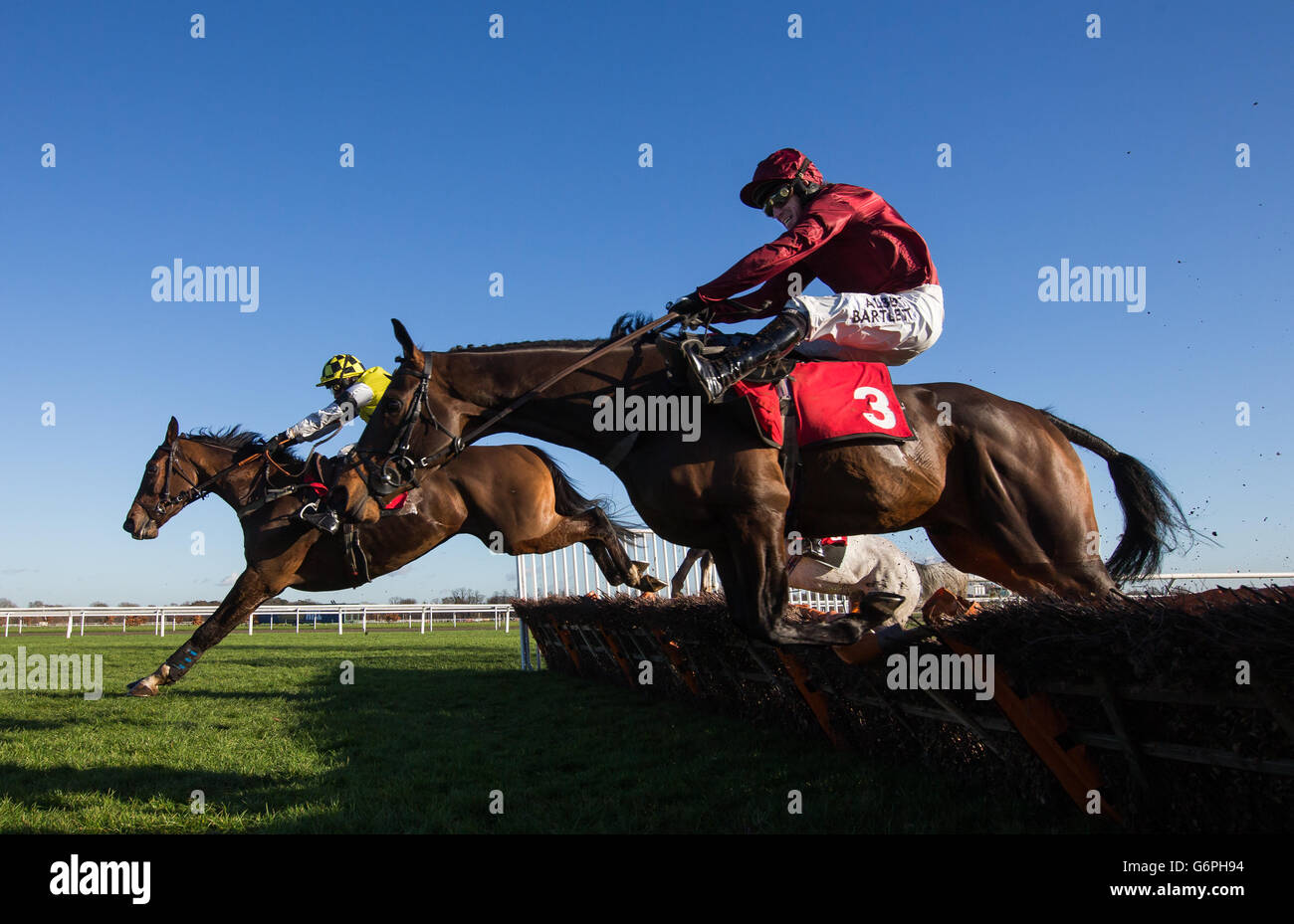 Goodwood Mirage, (no 3) ridden by Tony McCoy crashes through the last before overhauling The Green Ogre (left) ridden by Tom Cannon to win The William Hill - In The App Store Juvenile Hurdle (Class 4) Stock Photo
