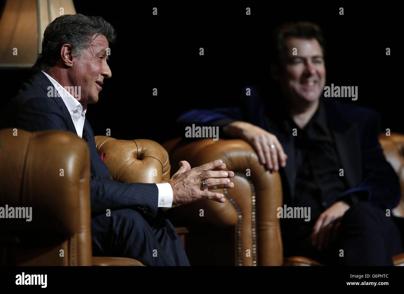 Sylvester Stallone appears onstage with interviewer Jonathan Ross at the London Palladium in Central London for An Evening with Sylvester Stallone on January 11, 2014. Stock Photo
