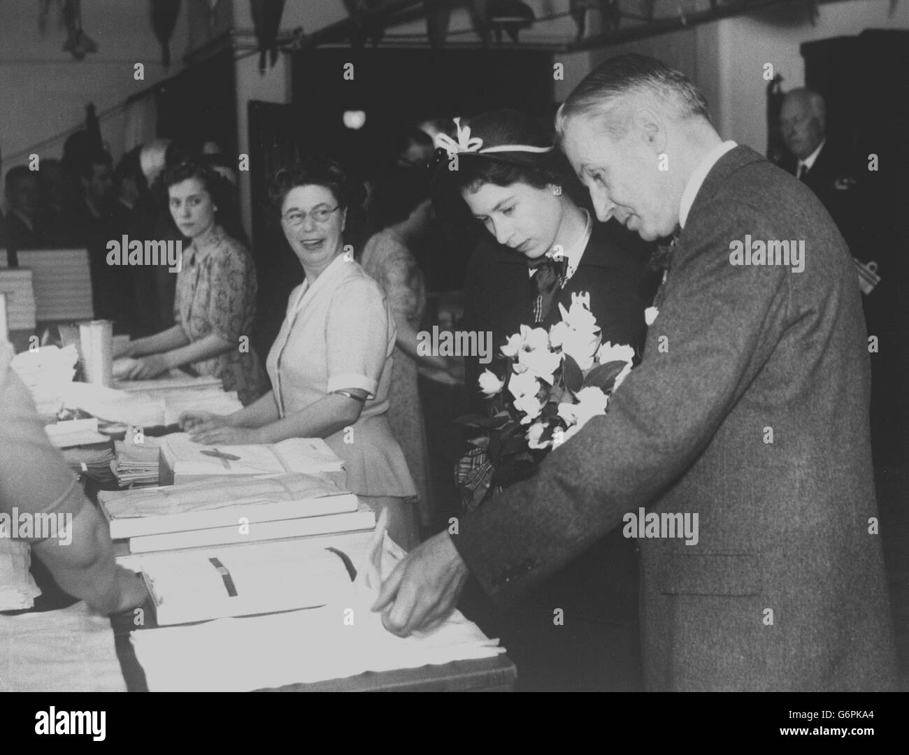 Aircraft workers at Short Brothers and Harland in Belfast give a royal welcome to Princess Elizabeth and Prince Philip, Duke of Edinburgh, during their tour of the hangar on their way to a naming ceremony. The royal couple named a four-engine Short Solent flying boat 'Aotearoa 11', the first aircraft produced in Belfast by the Short concern. The Flying boat has been built for the Tasman Empire Airways, New Zealand, and is one of four to go into service on the New Zealand-Australia route. Stock Photo