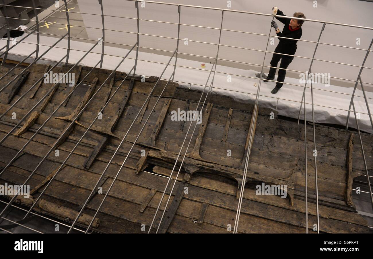 A technician works on the the steel frame, at the British Museum in London, that reconstructs the shape of the Rosklide 6, the longest viking warship which was discovered in Denmark in 1997. Stock Photo
