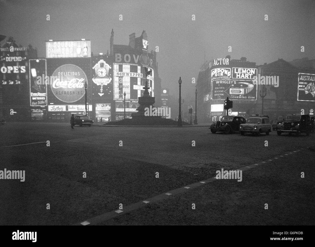 Morning looks like midnight in Piccadilly Circus at 9:30 am. as with the worst fog of the winter still shrouding London, electric signs blaze through the gloom and vehicles use their lights. Stock Photo
