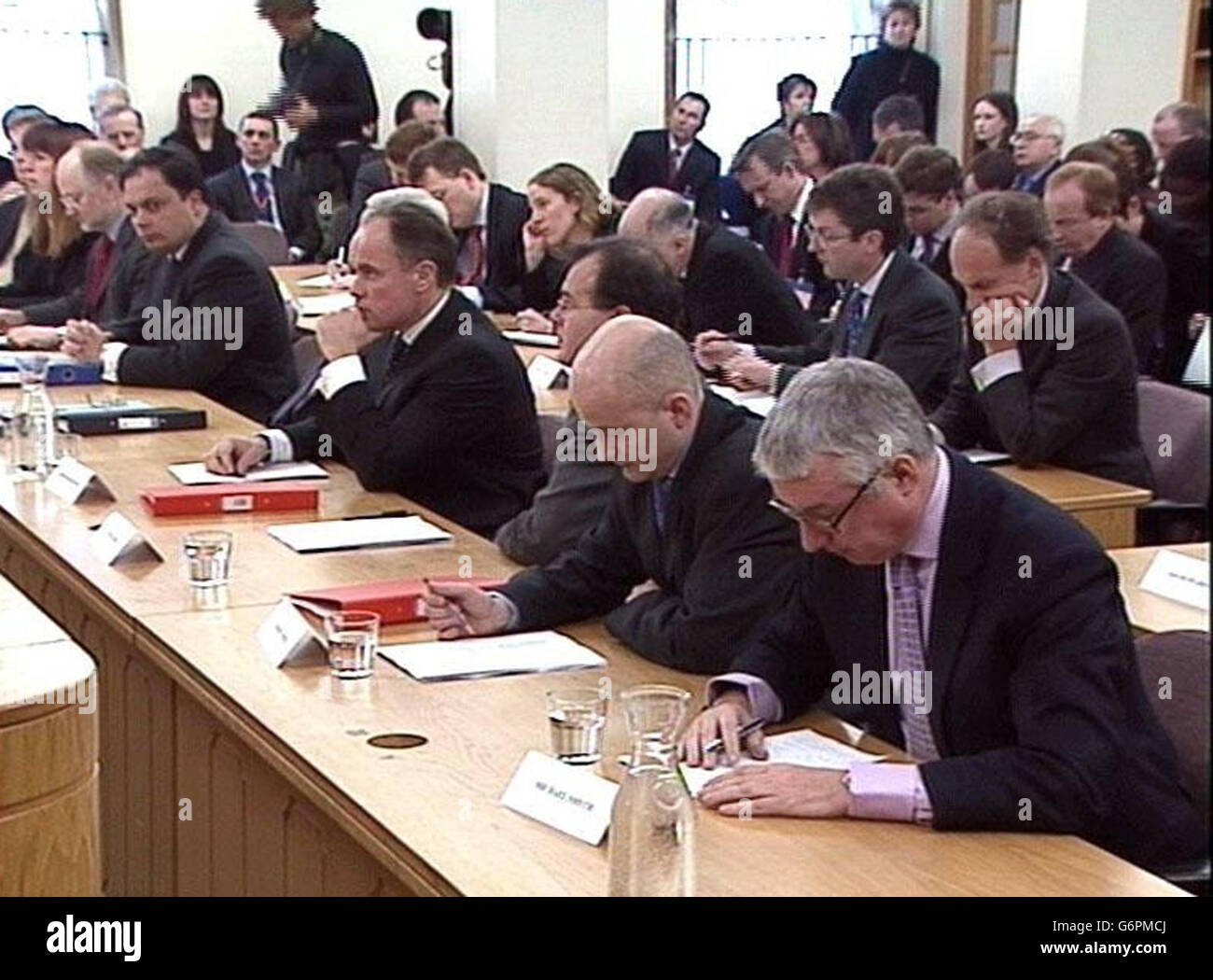 Lawyers and solicitors listen as Lord Hutton, speaks at the High Court in central London, announces the results of his inquiry into the events surrounding the death of Government scientist Dr David Kelly. Stock Photo