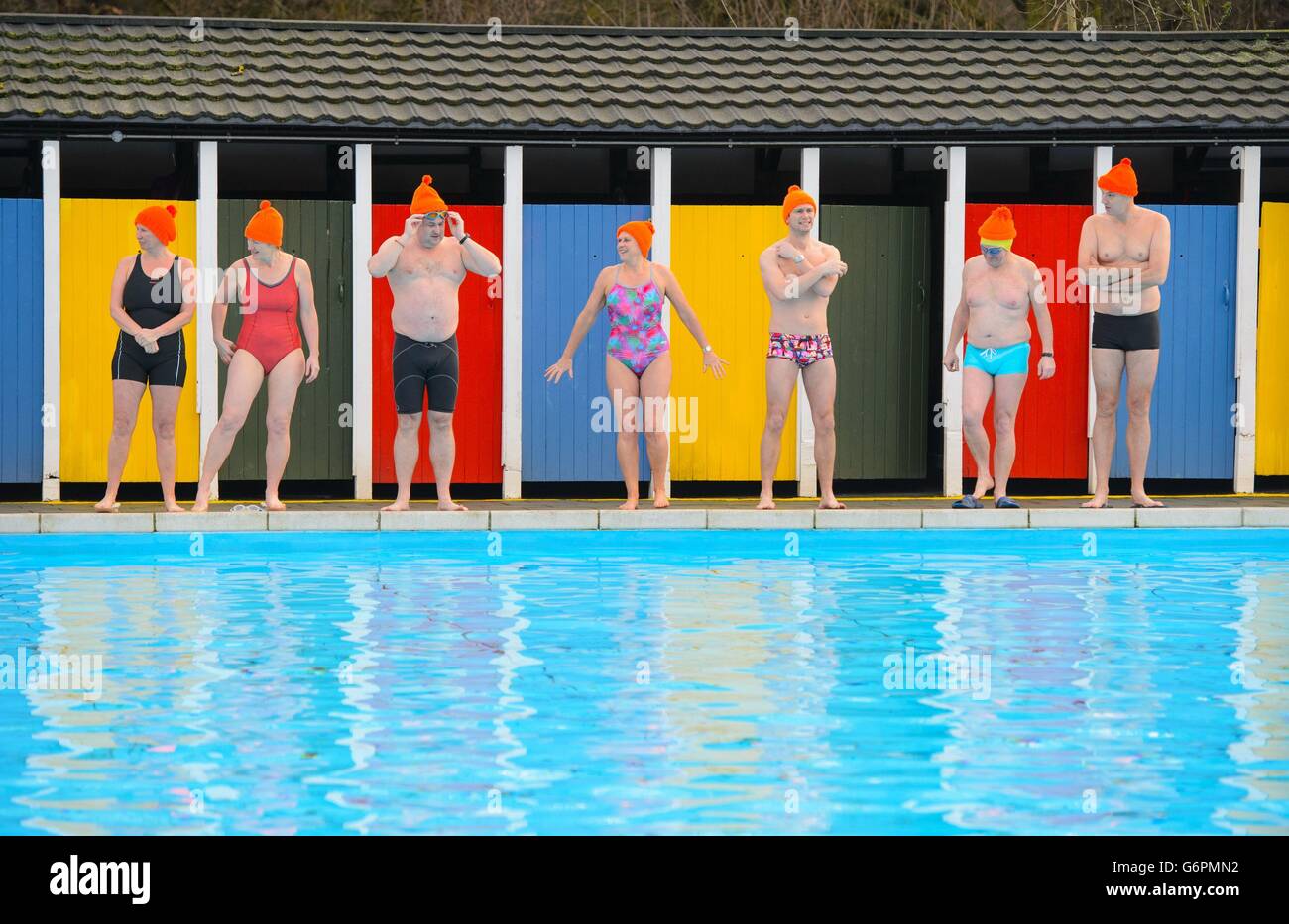 Cold weather swimmers prepare to take a swim at Tooting Bec Lido, in Tooting, south London, wearing orange bobble hats in support of homeless charity St Mungo's annual fundraising event Woolly Hat Day, which takes place on January 31 to raise awareness of homelessness in winter. Stock Photo