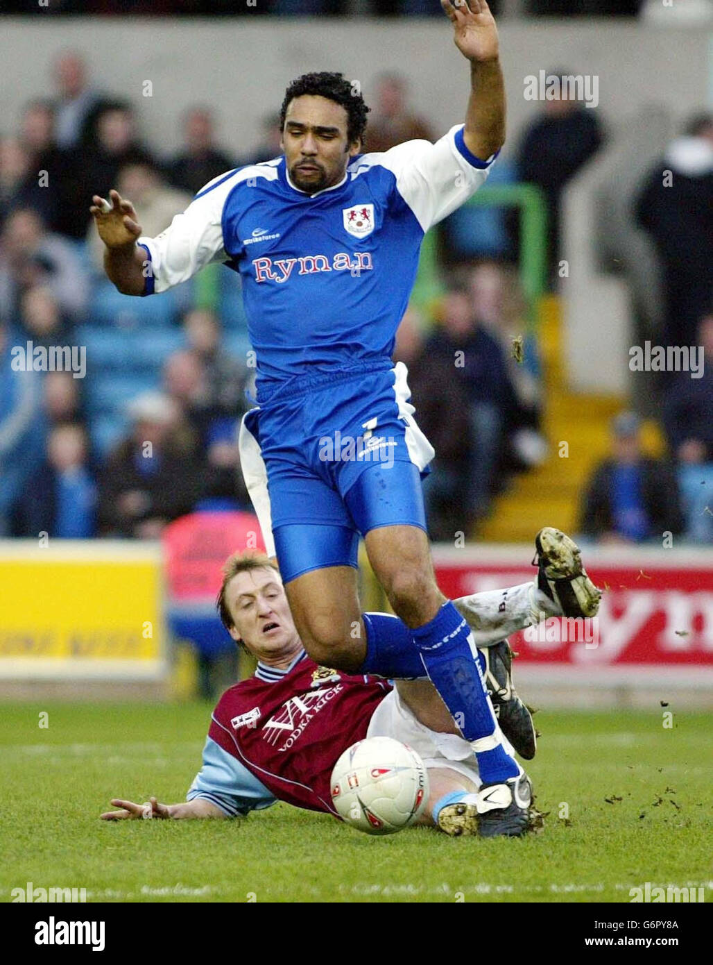 Burnley's Tony Grant (left) slides in behind Paul Ifill of Millwall, during the FA Cup 5th round match at The New Den, Millwall. Final score: Millwall 1, Burnley nil. . Stock Photo