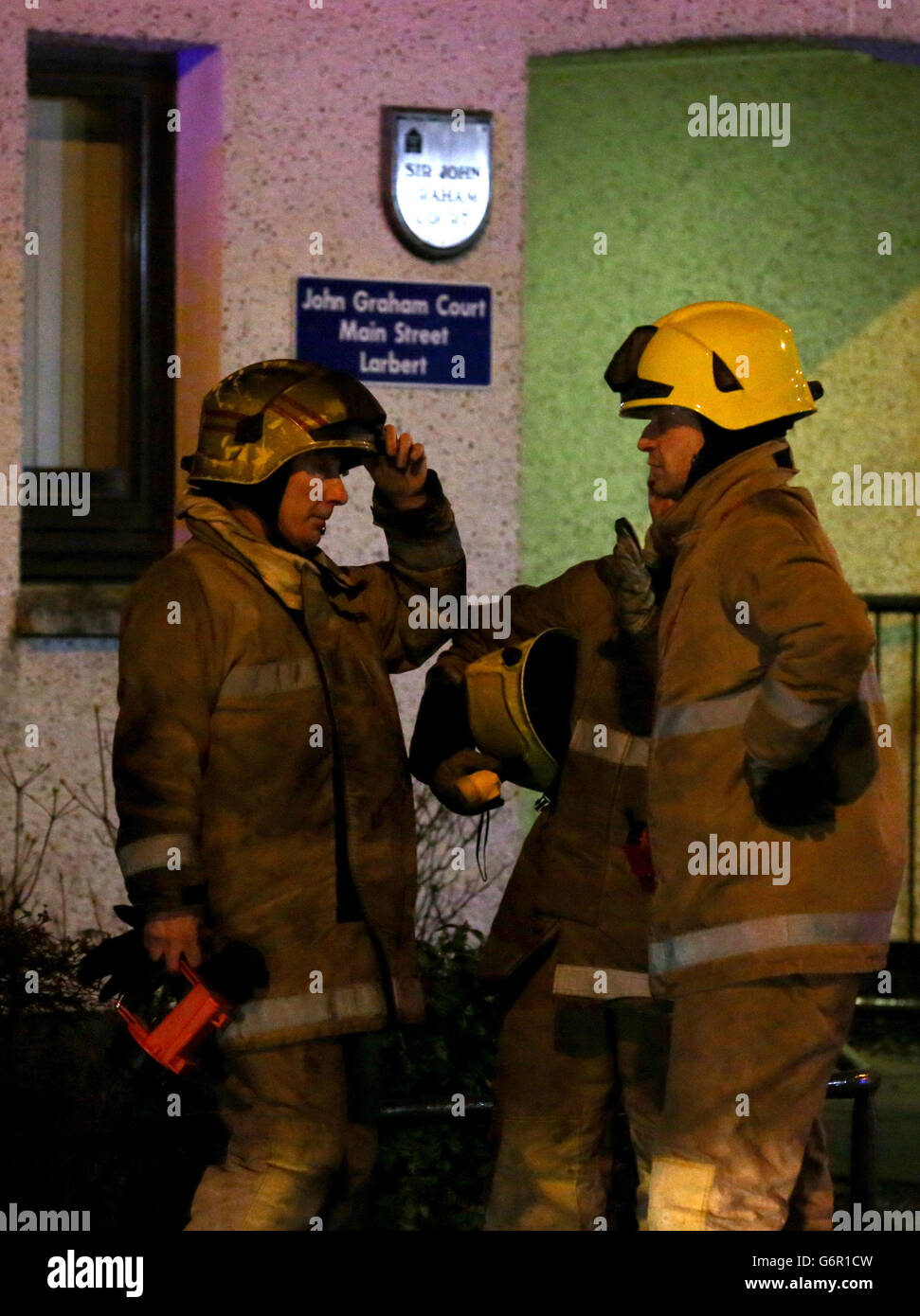 Firefighters at a burnt out flat after residents were evacuated from a
