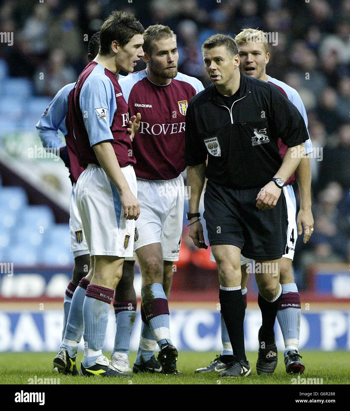 Referee Mark Halsey ignores the pleads from Aston Villa's Gareth Barry (left) , Olof Mellberg and Marcus Allback (right) after the penalty foul on Arsenal's Kanu (lying down) that lead to Thierry Henry scoring the second goal during the FA Barclaycard Premiership match at Villa Park, Birmingham. Final score Aston Villa 0-2 Arsenal. Stock Photo