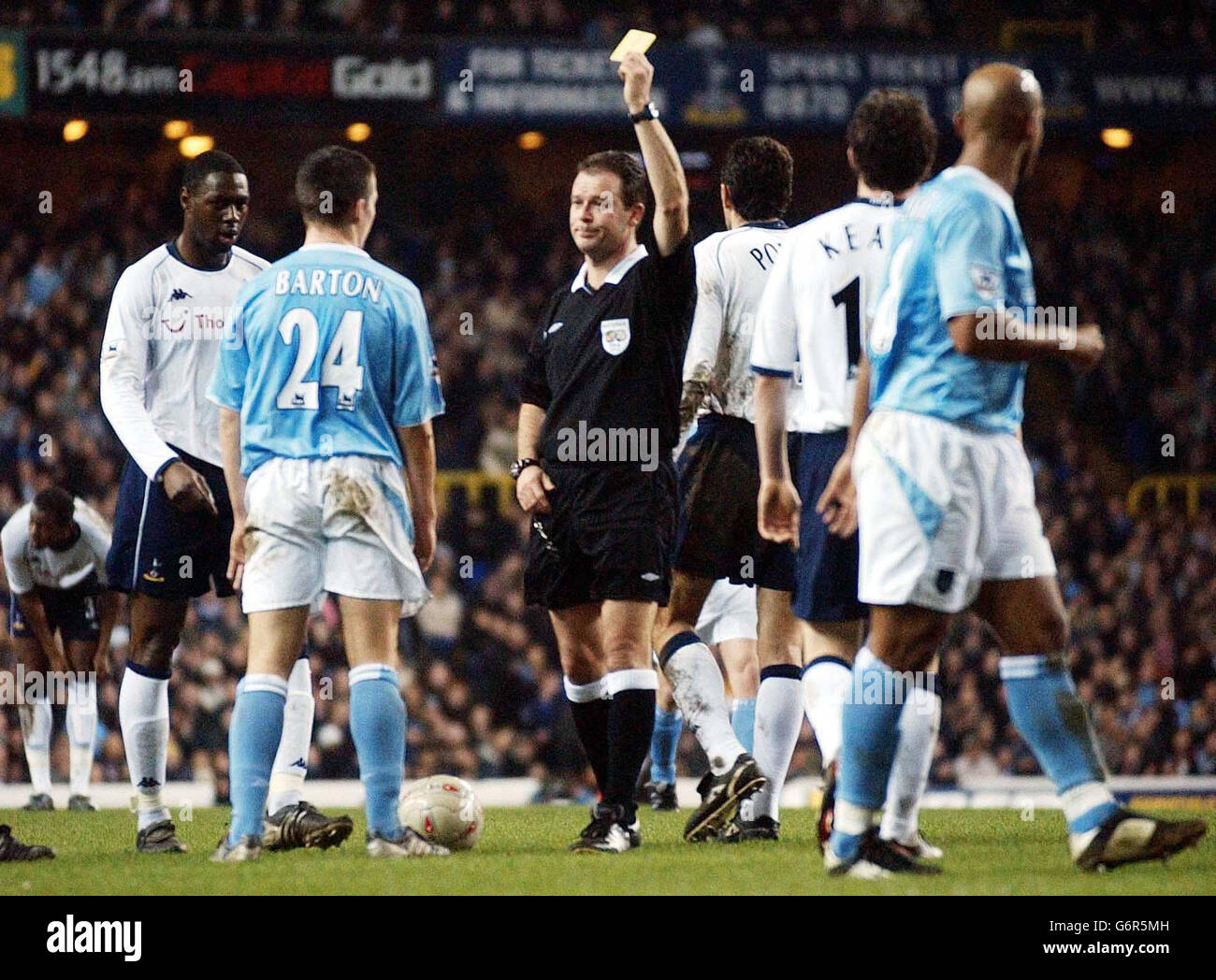 City's Joey Barton (second left) is yellow carded by referee Rob Styles (centre) during the FA Cup fourth round replay match against Tottenham Hotspur at White Lane, London. Manchester
