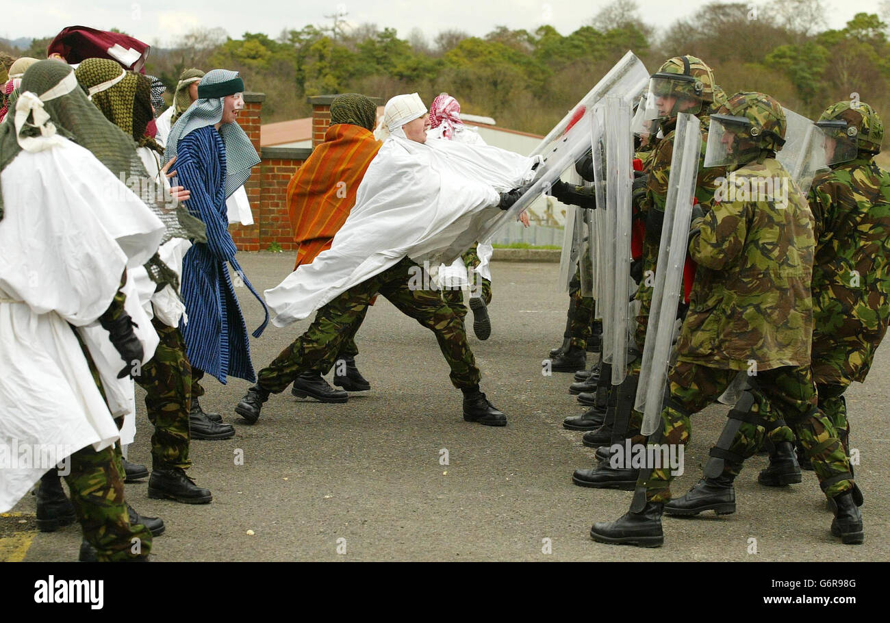 Wearing curtains, bed sheets and dressing gowns soldiers from The 1st Battalion The Cheshire Regiment enact a scene of civil unrest at Bulford Barracks near Amesbury, Wilts, in front of the Prince of Wales during his visit as Colonel-in- Chief. The Regiment are about to deploy to Iraq for peace keeping duties. Stock Photo