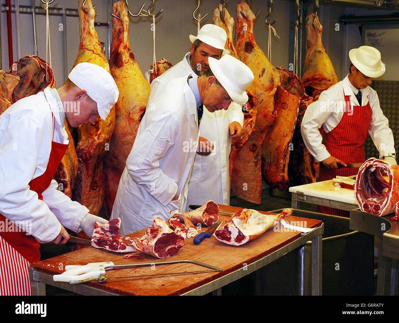 The Prince of Wales (centre left) inspects the meat at a butchers shop ...