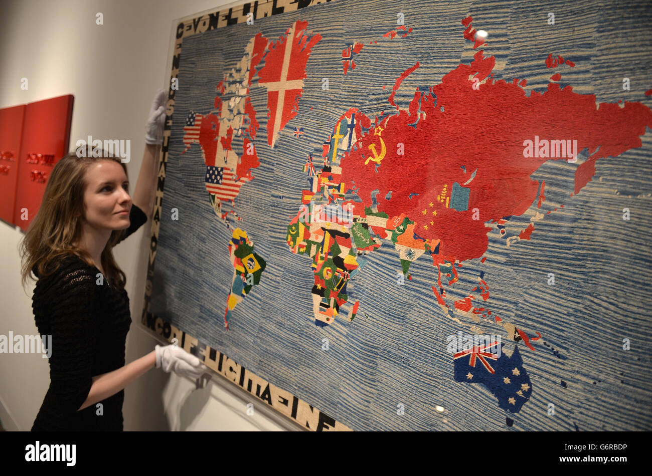 A Christie's employee poses with 'Mappa' by Alighiero Boetti during a preview of Christie's Eyes Wide Open: An Italian Vision sale at Christie's, Mayfair, London. Stock Photo