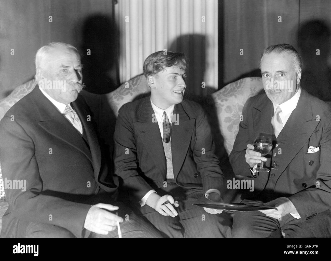 Yehudi Menuhin (centre) handing over an 'HMV' record to Sir Thomas Beecham at Grosvenor House. On the left is Sir Edward Elgar. Stock Photo