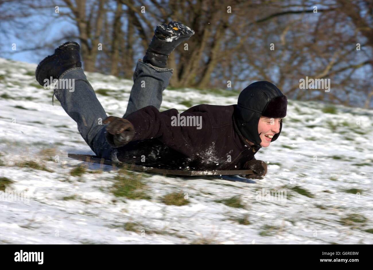 Children, who were given a well received day off from school due to the wintry conditions, done their winter woollies and toboggan down Primrose Hill, London, on their make-shift sledges as the Arctic blast continues across the country. Stock Photo