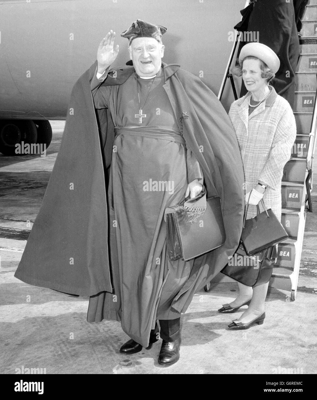 Dr Michael Ramsey, Archbishop of Canterbury, his cloak billowing in the