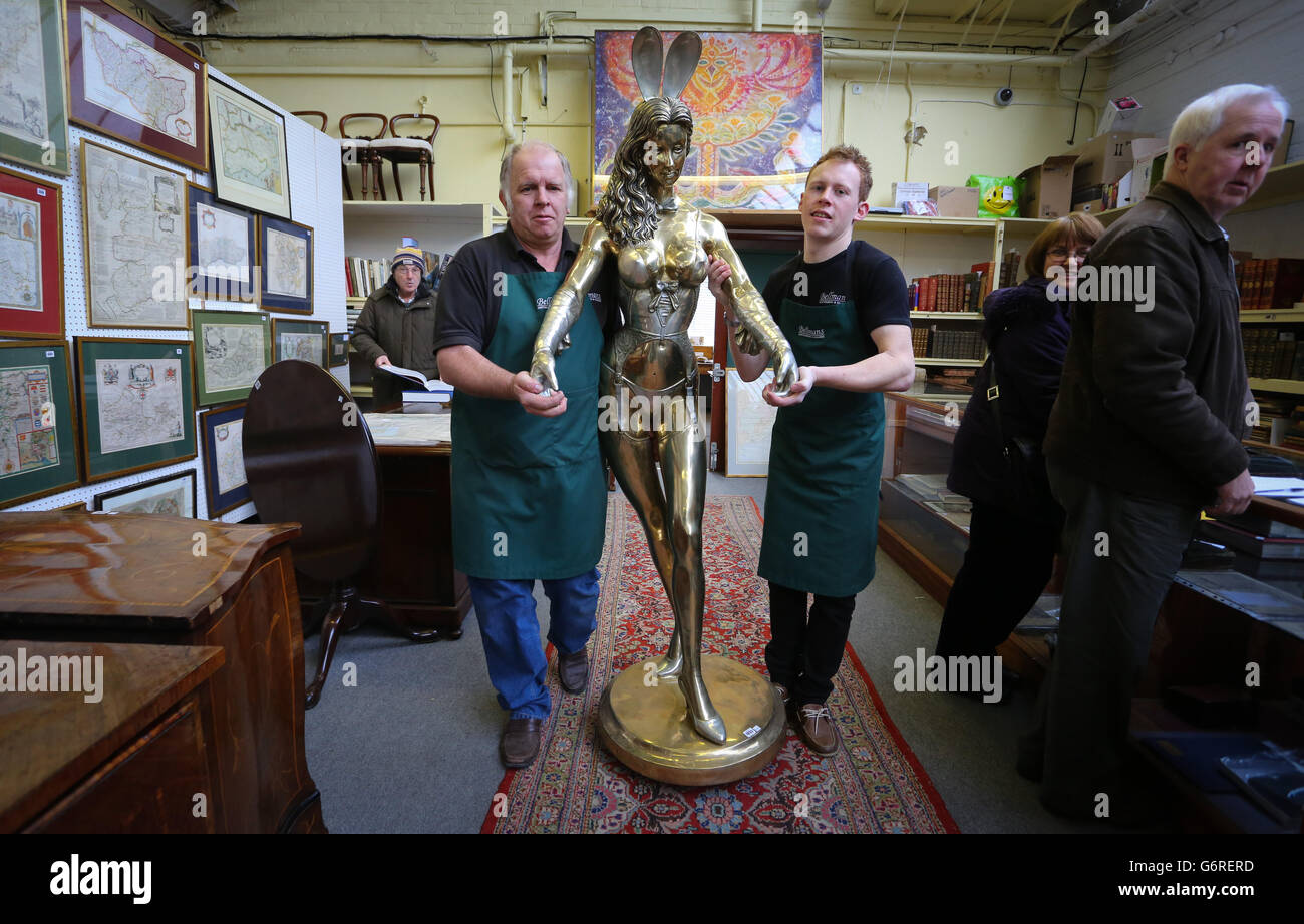 RETRANSMITED CORRECTING CAPTION Tim Allcorn (left) and Lee Cox (right) sale room porters at Bellmans Auctioneers in Wisborough Green, West Sussex, carry a 6ft gilt bronze Playboy Bunny Girl Waitress by sculptor Rudolfo Bucacio into the sale room as a collection of his work features in a sale of antiques and interiors at the auction house later this week. Stock Photo
