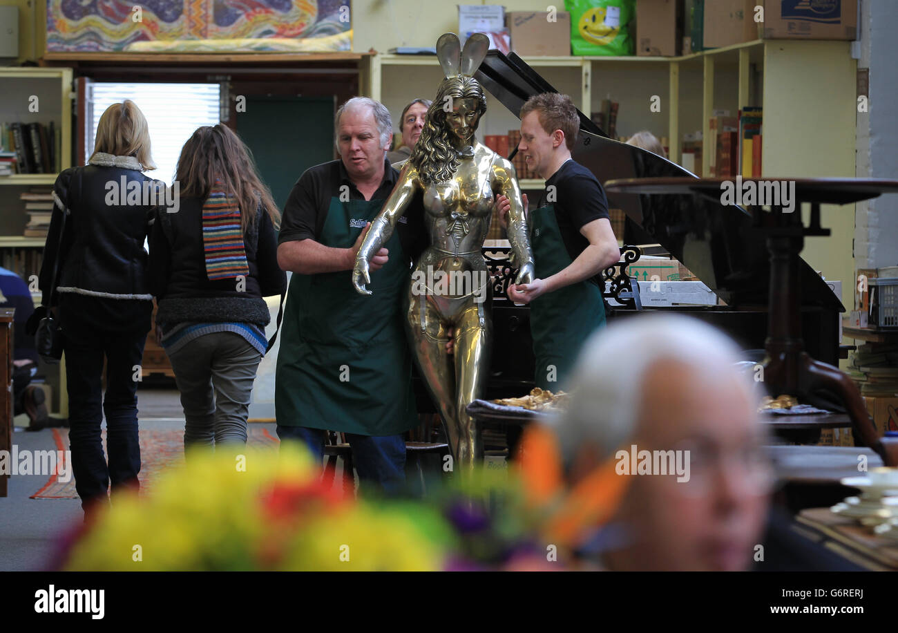RETRANSMITED CORRECTING CAPTION Tim Allcorn (left) and Lee Cox (right) sale room porters at Bellmans Auctioneers in Wisborough Green, West Sussex, carry a 6ft gilt bronze Playboy Bunny Girl Waitress by sculptor Rudolfo Bucacio into the sale room as a collection of his work features in a sale of antiques and interiors at the auction house later this week. Stock Photo