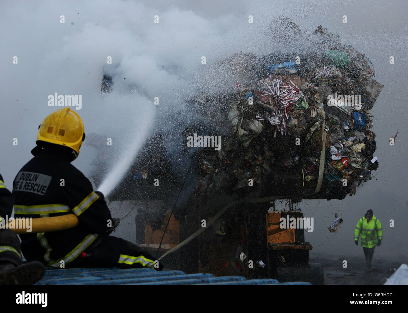 A vehicle transports waste material from the building as members of the