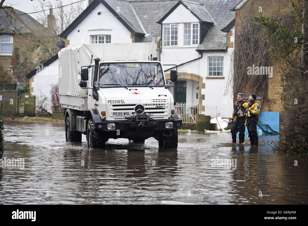 A specialist Red Cross off road vehicle approaches emergency personnel as it delivers fire wood to the village of Muchelney in Somerset after it was cut off by flooding. Stock Photo