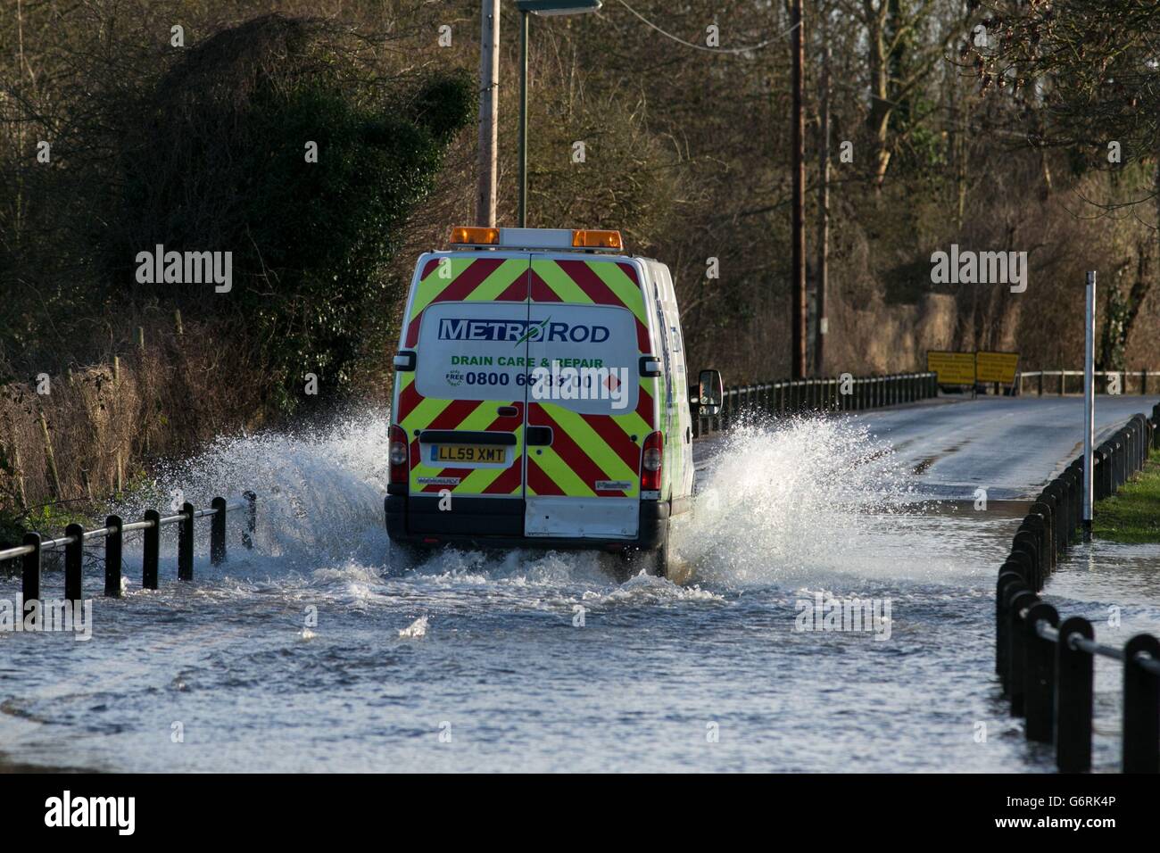 A van drives through a flooded road next tot the River Thames in Chertsey, Surrey. Stock Photo