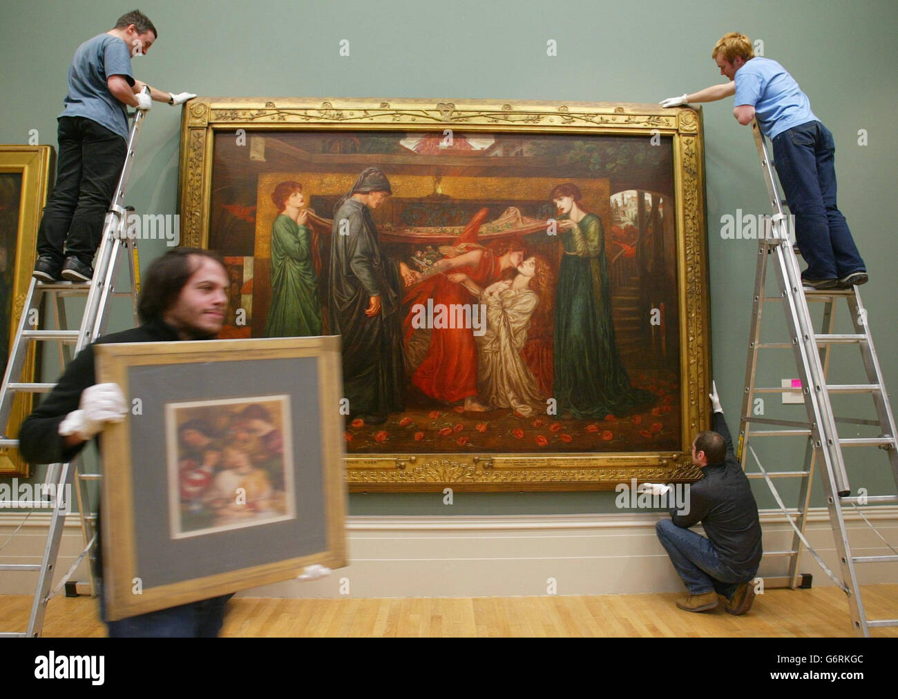 Curators at Liverpool's Walker Art Gallery dismantle the popular exhibition of the work of artist Dante Gabriel Rossetti (1828-1882). The show which includes the painting, Dante's dream, seen here being removed from the wall, is moving to the Van Gogh museum in Amsterdam, where it will go on run from Feb 27 to June 6. Stock Photo