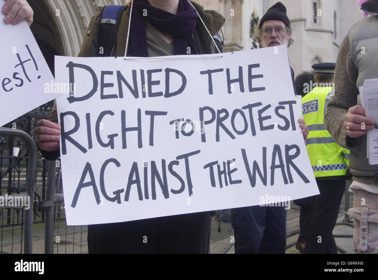 An anti-war protester holds up a placard outside the High Court in central London, after a group of demonstrators won their legal battle over a police decision to detain three coachloads of peace activists on their way to an anti-war protest. The ruling was a victory for about 60 of the 120 passengers. They took legal action after being prevented from attending the vigil at RAF Fairford in Gloucestershire in March last year. Stock Photo