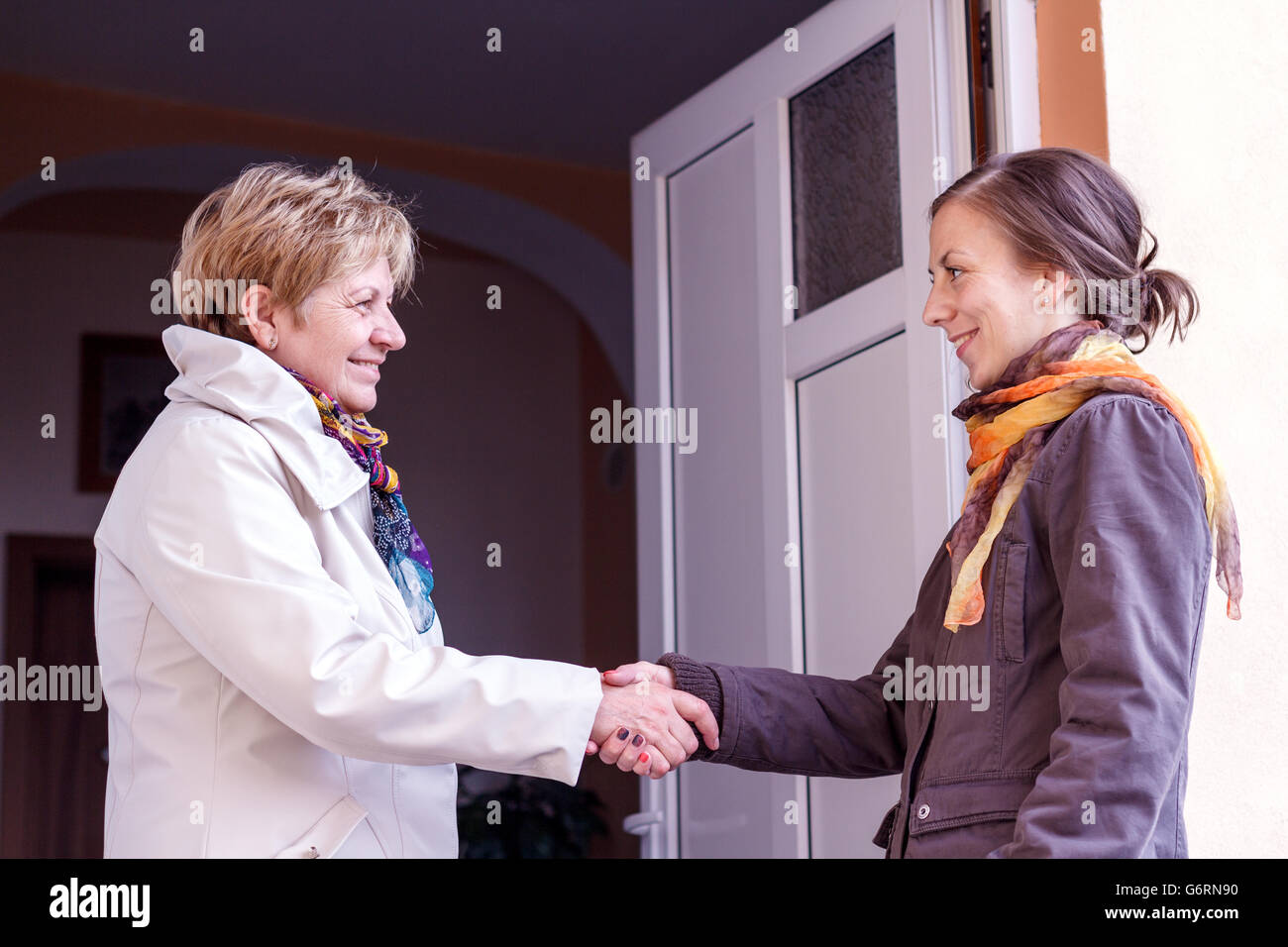 Woman greeting in door hi-res stock photography and images - Alamy